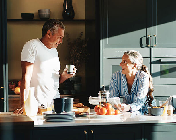 Couple having breakfast and talking in their kitchen.